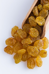 golden raisins on a white acrylic background