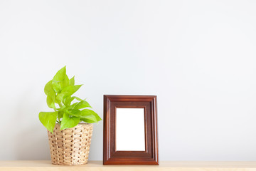 Golden pothos and photo frame on wood table in living room