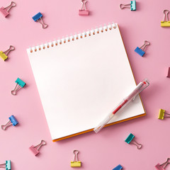 Flat lay picture with blank open notepad and different accessories on colored surface.