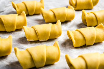 French pastry croissants or rolls ready to bake on baking tray