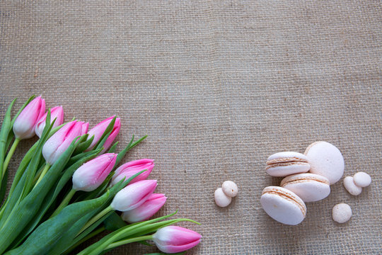 Mother's day background with tulips bouquet and pink macarons.