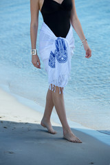 Pretty young girl walking on the sea with white classic beach towel wrapped on her waist - Image