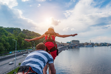 Ropjumping - jumping from the bridge on an elastic band to the river. The girl in the red dress...