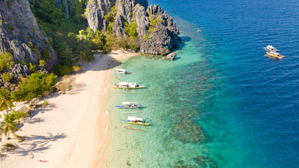 White sand beach near the rocks and boats.Palawan,Busuanga,Tropical beach for tourists aerial view