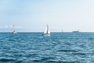 Fototapeta premium Luxury yachts in open sea at beautiful sunny day. Active lifestyle for active people. Tropical vacation. Weekend getaway from city. Natural landscape. Horizontal image with space for text and design.
