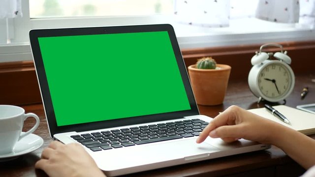 4K. close-up woman working at home with notebook laptop, using finger with keyboard and touchpad for slide. computer laptop with blank green screen chroma key.