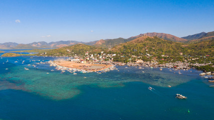 Fototapeta premium Berth with boats in the town of Coron. Palawan. Philippines.Coron Cityscape with Pier and Sulu Sea.City with a pier by the sea aerial view