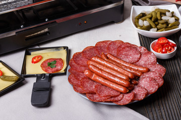 young woman is preparing a traditional Swiss cheese raclette