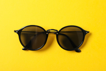 Sunglasses on color background, space for text and closeup. Fashionable accessories