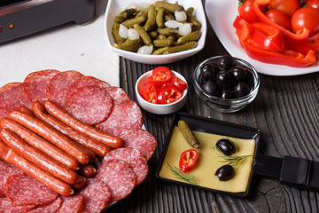 young woman is preparing a traditional Swiss cheese raclette