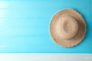 Fototapeta na wymiar Straw hat on white table against color background, space for text. Summer vacation backdrop
