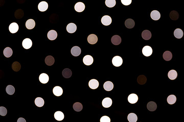 Unfocused abstract white bokeh on black background. defocused and blurred many round light