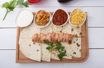 Cooked chicken kebab on a wooden board