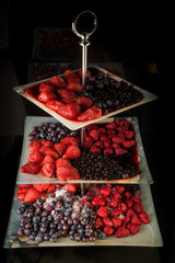 assorted frozen thawed berries served on three leveled plate