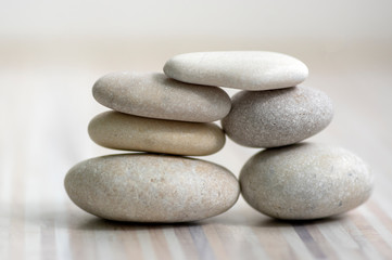 Fototapeta na wymiar Harmony and balance, cairns, simple poise stones on wooden light white gray background, simplicity rock zen sculpture