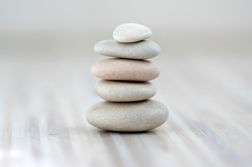 Obraz na płótnie Canvas Harmony and balance, cairns, simple poise stones on wooden light white gray background, simplicity rock zen sculpture