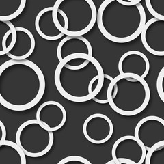 Abstract seamless pattern of randomly arranged white rings with soft shadows on black background