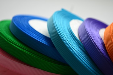 bobbins of thin colored rep ribbon on white background