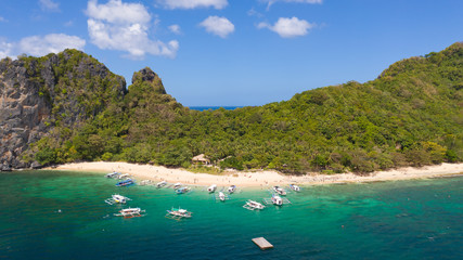 Fototapeta premium White sand beach near the rocks and boats.Palawan,Busuanga,Tropical beach for tourists aerial view