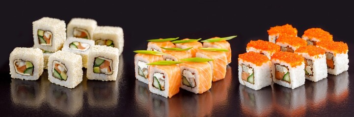 Elite sushi rolls on a black background. Assortment of rolls with different fillings.