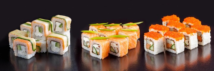 Elite sushi rolls on a black background. Assortment of rolls with different fillings.