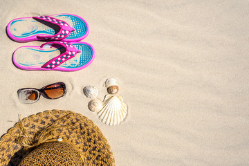 Fototapeta na wymiar Summer background with vacation accessories on the beach, top view on sand