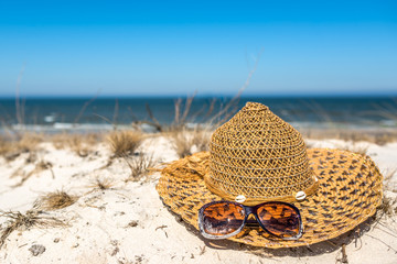 Blue sky and white sand vacation sea beach with sun hat and sunglasses, summer holiday landscape