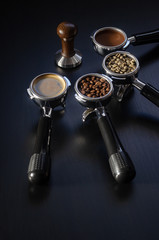 four holders with green, roasted, ground, and hot coffee and tamper, equipment for making freshly brewed coffee