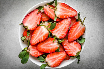 Fresh organic strawberries. Plate with juicy strawberry pieces, sliced fruit, overhead