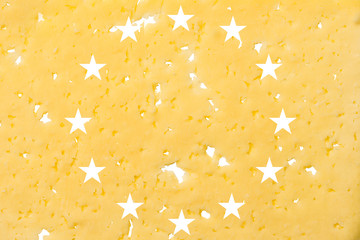 EU flag cut out of cheese, as a symbol of the import or export of cheese on a white isolated...