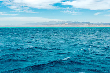 Naklejka na ściany i meble Seascape, view of the blue sea with high bald mountains in the background