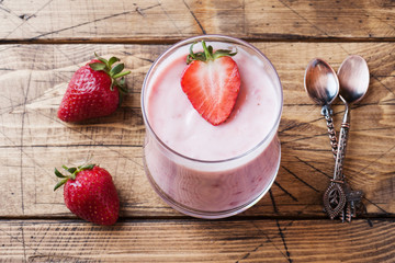 Homemade yogurt with fresh strawberries in glasses on a wooden background. Selective focus. Copy space.