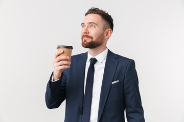 Businessman posing isolated over white wall background drinking coffee.