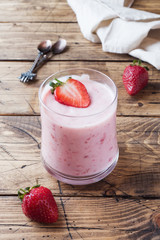 Homemade yogurt with fresh strawberries in glasses on a wooden background. Selective focus. Copy space.