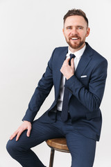 Young businessman posing isolated over white wall background.