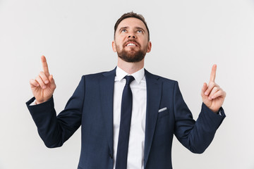 Handsome young businessman posing isolated over white wall background pointing.
