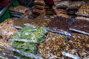Transparent plastic package full of various dried fuits stacked in piles for sale at market, dried fruits, asian market - Image