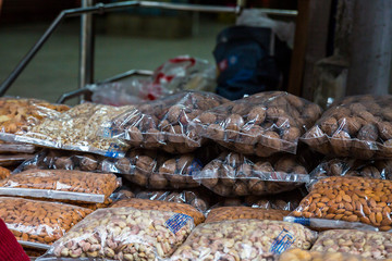 Transparent plastic package full of various dried fruits stacked in piles for sale at market, dried fruits, asian market - Image