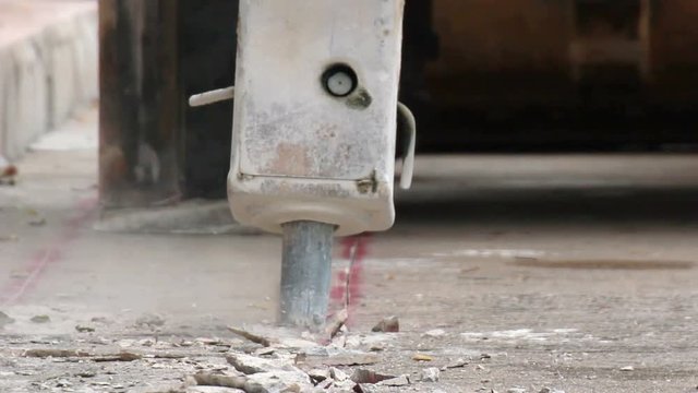 Concrete demolition on high power excavator is breaking and destroying cement floor road surface for preparing to install new water pipes system. - Powered by Adobe