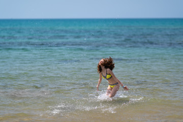 Carefree young woman frolicking in the sea