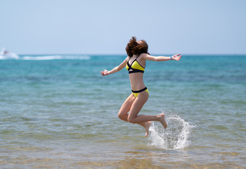 Young energetic woman jumping in the sea
