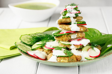 Vegetarian fried zucchini pancakes, asparagus and greens served with cucumbers and radishes.