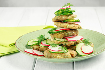 Vegetarian fried zucchini pancakes, asparagus and greens served with cucumbers and radishes.