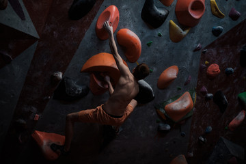 Athletic man practicing in a bouldering gym