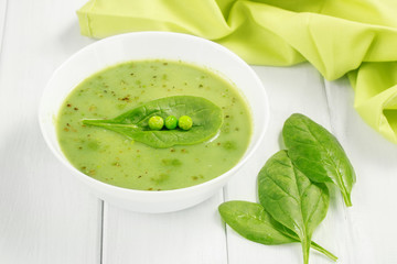 Healthy food vegan soup with asparagus and spinach and green peas on a white background.