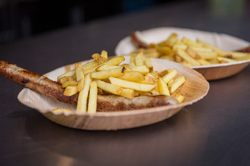 Bratwurst mit Pommes Frites auf Bambusteller