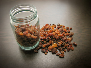 Brown raisins seamless in a glass jar on the wooden table