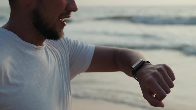 Active lifestyle man tourist looking tech smartwatch smart watch. Closeup macro close up arm beach touch screen on wrist band of person relaxing use sport application ai audio message voice
