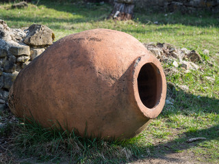 Old kvevri (qvevri) in front of the Ikalto cathedral, Kakheti, Georgia. Kvevri is a large earthenware vessel used for the fermentation and storage of wine, often buried below ground level.