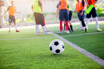 Obraz na płótnie Canvas soccer ball on green artificial turf with blurry soccer players